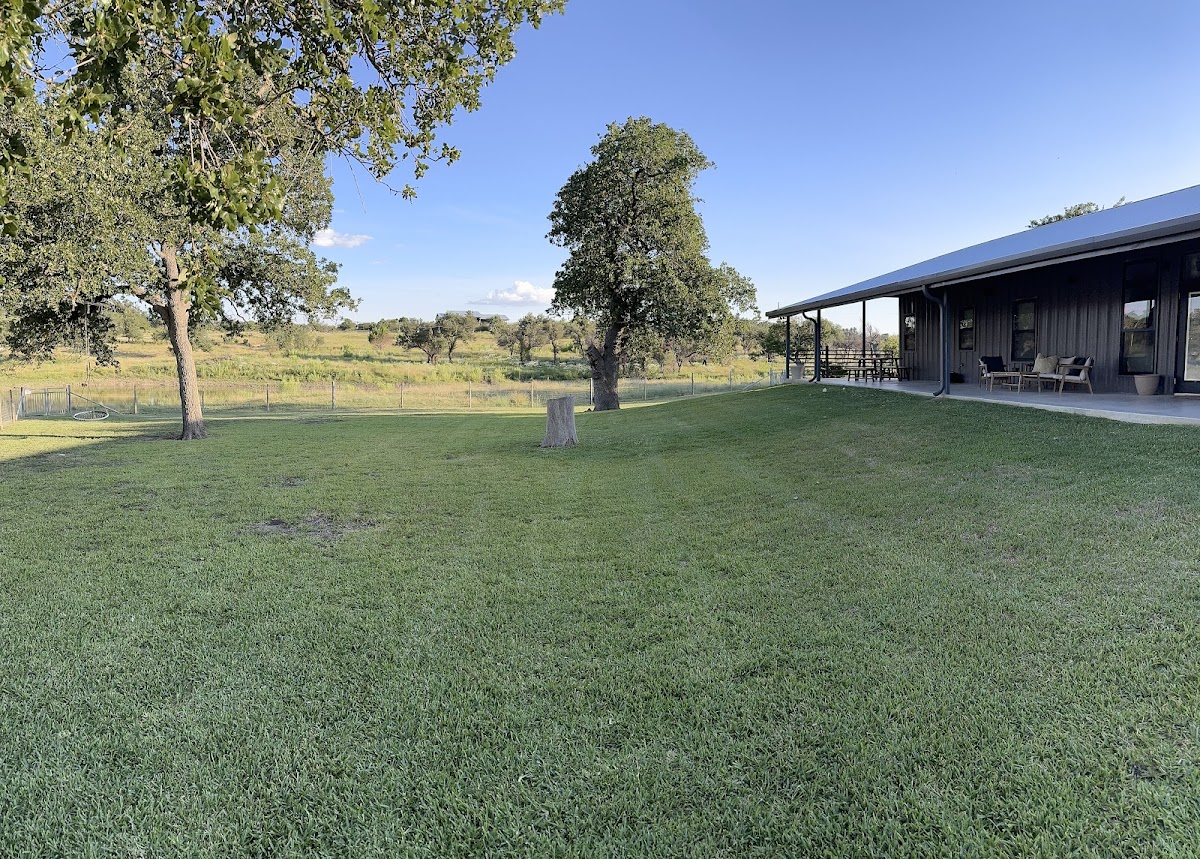 A large Hill Country property with a perfectly maintained lawn and oak trees